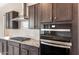 New kitchen features granite countertops, black oven, and dark wood cabinetry at 16679 W Saguaro Park Ln, Surprise, AZ 85387