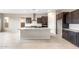 Kitchen island features a gray countertop, stainless faucet, and dark cabinets at 16679 W Saguaro Park Ln, Surprise, AZ 85387