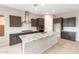 Well-lit kitchen featuring dark cabinets, white backsplash, and granite countertops at 16679 W Saguaro Park Ln, Surprise, AZ 85387