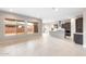 Bright, open-concept living space with tile floors, abundant natural light, and kitchen view at 16679 W Saguaro Park Ln, Surprise, AZ 85387
