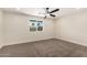 Bright bedroom featuring ceiling fan, neutral walls, carpet flooring and a large window at 17040 N 39Th Ave, Glendale, AZ 85308