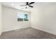 Cozy bedroom with ceiling fan, carpet flooring, and a sunlit window at 17040 N 39Th Ave, Glendale, AZ 85308