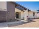 Exterior entrance with black door, white brick column, and minimal rock landscaping at 17040 N 39Th Ave, Glendale, AZ 85308