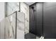 Modern shower featuring black and marble tile, modern fixtures, and glass door at 17040 N 39Th Ave, Glendale, AZ 85308