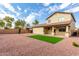 Spacious backyard featuring a well-maintained lawn, gravel landscaping, and covered patio for outdoor entertaining at 18096 N Arbor Dr, Maricopa, AZ 85138