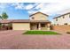 View of the home's rear exterior and backyard featuring gravel landscaping, a covered patio, and a small patch of lawn at 18096 N Arbor Dr, Maricopa, AZ 85138