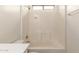 The bathroom has an all-white tiled shower-tub combo with a soap ledge at 18096 N Arbor Dr, Maricopa, AZ 85138
