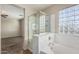 Bright bathroom with glass shower and soaking tub next to glass block window at 18096 N Arbor Dr, Maricopa, AZ 85138