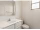 Bright half-bathroom featuring white fixtures, a toilet, and a single window at 18096 N Arbor Dr, Maricopa, AZ 85138