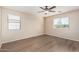 Bright bedroom with wood-look floors, ceiling fan, and two windows with blinds at 18096 N Arbor Dr, Maricopa, AZ 85138