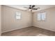 Bedroom featuring wood-look floors, two bright windows and a ceiling fan at 18096 N Arbor Dr, Maricopa, AZ 85138