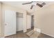 Bedroom with closet, ensuite bathroom, wood-look floors, and ceiling fan at 18096 N Arbor Dr, Maricopa, AZ 85138