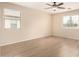 Large bedroom with hardwood floors, two windows, and a ceiling fan at 18096 N Arbor Dr, Maricopa, AZ 85138