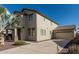 View of the two-story home exterior featuring a long driveway leading to a two-car garage at 18096 N Arbor Dr, Maricopa, AZ 85138