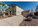 View of the two-story home exterior featuring a long driveway leading to a two-car garage at 18096 N Arbor Dr, Maricopa, AZ 85138