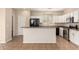 Bright kitchen featuring white cabinets, stainless steel appliances, and tiled floors at 18096 N Arbor Dr, Maricopa, AZ 85138