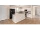 Clean kitchen with white cabinets, black appliances, and a convenient breakfast bar at 18096 N Arbor Dr, Maricopa, AZ 85138