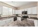 Well-lit kitchen with white cabinets, modern appliances, and tile backsplash at 18096 N Arbor Dr, Maricopa, AZ 85138