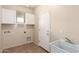 Functional laundry room with upper cabinets, utility sink, and tile flooring at 18096 N Arbor Dr, Maricopa, AZ 85138