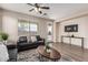 Relaxing living room with hardwood floors, a comfortable sofa, and a large window for natural light at 18096 N Arbor Dr, Maricopa, AZ 85138