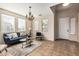 Inviting living room featuring tile floors, a chandelier, a comfortable blue sofa, and large windows at 18096 N Arbor Dr, Maricopa, AZ 85138