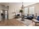 Inviting living room featuring tile floors, a chandelier, a comfortable blue sofa, and large windows at 18096 N Arbor Dr, Maricopa, AZ 85138