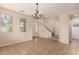 Spacious living area with tile flooring, a staircase, and large windows allowing ample natural light to brighten the room at 18096 N Arbor Dr, Maricopa, AZ 85138