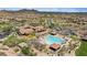 Aerial view of luxury community featuring a large pool, clubhouse, desert landscaping, and mountain views at 1915 N Bernard Cir, Mesa, AZ 85207
