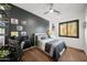 Stylish bedroom featuring a black accent wall, desk, and natural light at 20546 W Summit Pl, Buckeye, AZ 85396