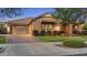 Well-manicured lawn and shrubbery enhance the exterior elevation of this charming home with a two-car garage at 20546 W Summit Pl, Buckeye, AZ 85396