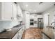Well-lit kitchen featuring white cabinets, modern appliances, and stylish backsplash at 20546 W Summit Pl, Buckeye, AZ 85396