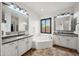 Bright and clean main bathroom with double sinks and a soaking tub by a window at 20546 W Summit Pl, Buckeye, AZ 85396