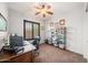 Office with brown carpet, ceiling fan, shuttered window, desk, and book shelf at 20546 W Summit Pl, Buckeye, AZ 85396