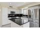 Modern kitchen with white cabinets, stainless steel appliances, an island, and black countertops at 20734 N 38Th St, Phoenix, AZ 85050