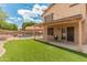The backyard has a covered patio, turf, and a pool enclosed by a black safety fence at 20809 N 1St Ave, Phoenix, AZ 85027