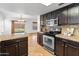Modern kitchen with stainless steel appliances, granite countertops, and dark cabinets at 20809 N 1St Ave, Phoenix, AZ 85027