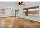 Spacious living room featuring travertine tile flooring, a ceiling fan, and sliding glass doors leading to the backyard at 20809 N 1St Ave, Phoenix, AZ 85027
