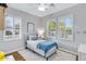 Sunlit bedroom featuring light gray walls, wood floors, large windows, and a comfortable bed with a blue blanket at 2150 S Lorena --, Mesa, AZ 85209