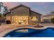 Beautiful backyard features a swimming pool, a covered patio with seating, and tasteful landscaping for outdoor enjoyment at 22166 N Lakeside Dr, Maricopa, AZ 85138