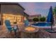 Spacious backyard features a sparkling pool, a cozy fire pit area, and ample seating for outdoor relaxation and entertaining at 22166 N Lakeside Dr, Maricopa, AZ 85138