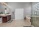 Bright bathroom featuring a soaking tub, a glass enclosed shower, and a dark wood vanity with double sinks at 22166 N Lakeside Dr, Maricopa, AZ 85138