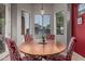 Bright breakfast nook features a round table, red chairs, and bay window, offering a cozy dining space at 22166 N Lakeside Dr, Maricopa, AZ 85138