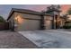 Spacious three-car garage with a concrete driveway and desert landscaping at 22166 N Lakeside Dr, Maricopa, AZ 85138