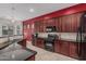Spacious kitchen with dark wood cabinets, granite countertops, stainless steel appliances, and mosaic tile backsplash at 22166 N Lakeside Dr, Maricopa, AZ 85138