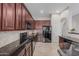 Modern kitchen boasts dark wood cabinets, black granite countertops, and stainless steel appliances, creating a sleek design at 22166 N Lakeside Dr, Maricopa, AZ 85138