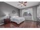 Cozy main bedroom with wood floors, a ceiling fan, and ample natural light offers a peaceful retreat at 22166 N Lakeside Dr, Maricopa, AZ 85138