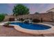 Relaxing pool area with waterfall feature and beautiful landscaping, creating a serene backyard retreat for cooling off at 22166 N Lakeside Dr, Maricopa, AZ 85138