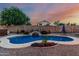 Tranquil pool and rock waterfall feature with lush landscaping, creating a private backyard oasis for leisure and relaxation at 22166 N Lakeside Dr, Maricopa, AZ 85138