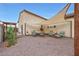 This backyard with gravel features a shaded dining area and is surrounded by lush green landscaping and trees at 22282 N 184Th Ln, Surprise, AZ 85387