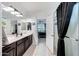 A well-lit bathroom features a modern vanity, a shower with black curtains, and access to the bedroom at 22282 N 184Th Ln, Surprise, AZ 85387